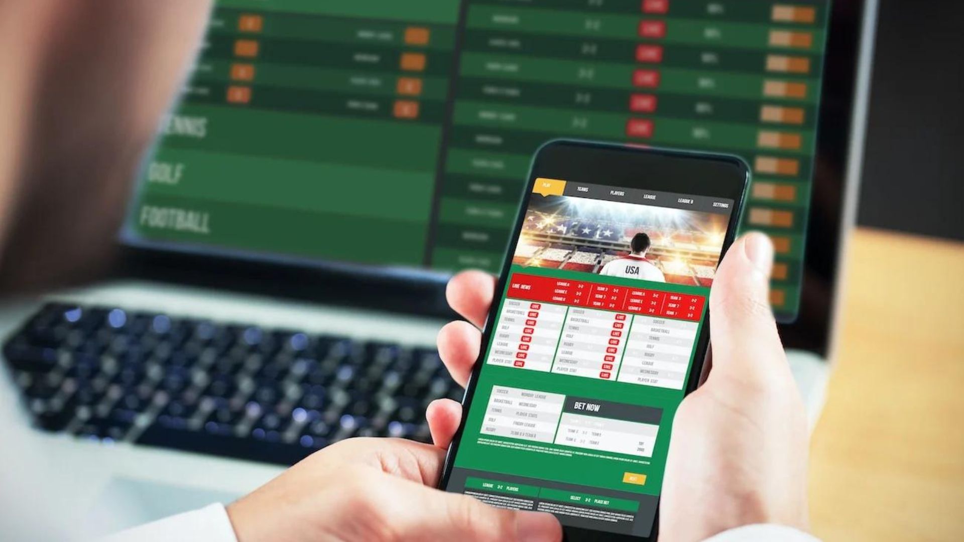 a person who is football betting on smartphone, laptop on the desk with betting odds